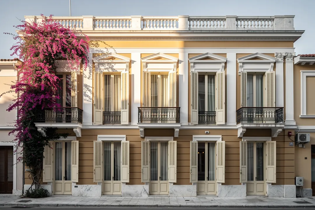 Neoklassizistische Fassade in Kolonaki mit verzierten Balkonen und blühender Bougainvillea